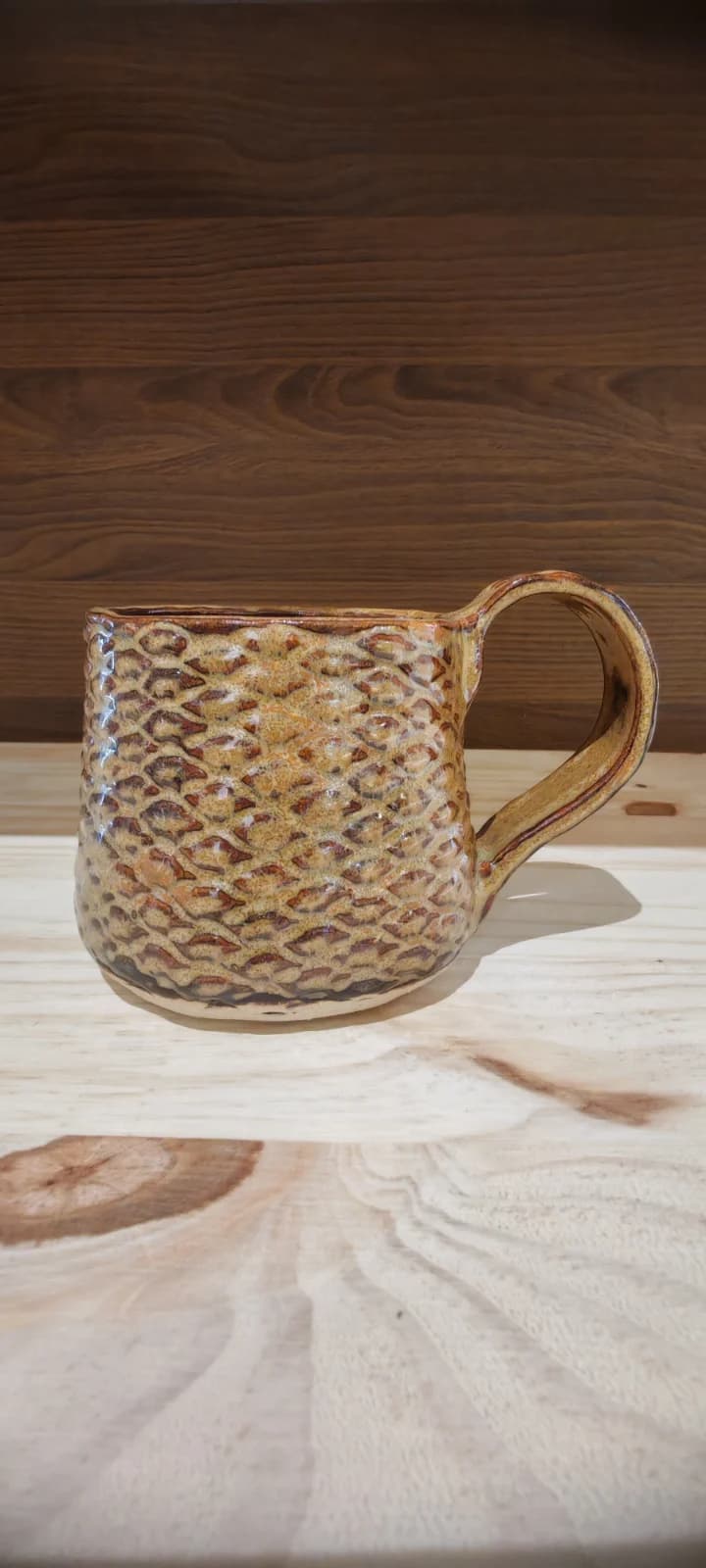 Tasse en céramique aux teintes ocres et brunes avec texture en relief façon écailles de pomme de pin